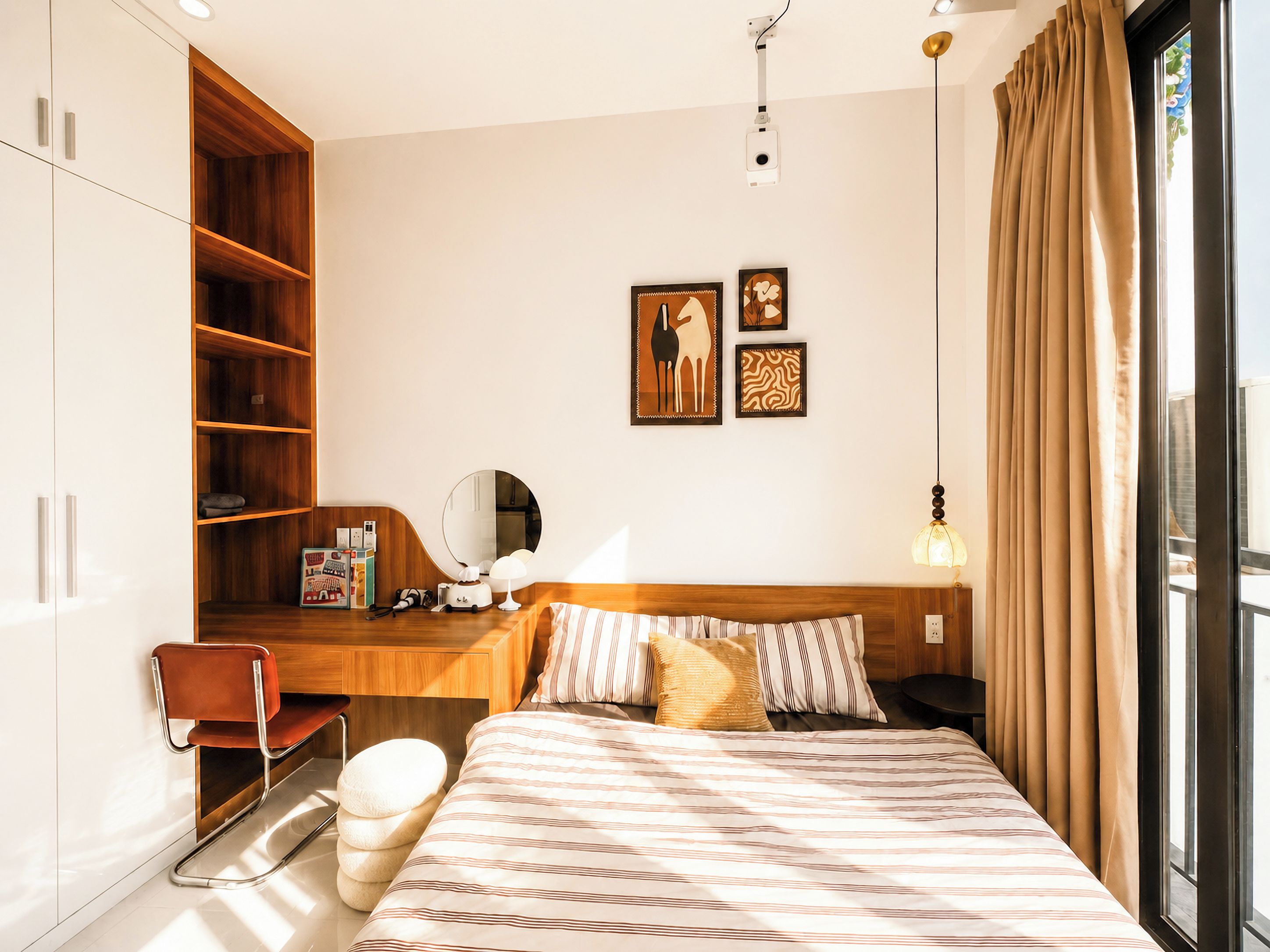 A modern bedroom with a bed, bedside table, lamp, and a wardrobe.