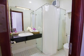 A modern bathroom with a glass shower enclosure, a white sink, and a toilet. - Khach san San Ho (Tam Thang)