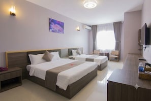 A hotel room with two beds, a desk, a chair, a TV, and a window with curtains. - Khach san San Ho (Tam Thang)