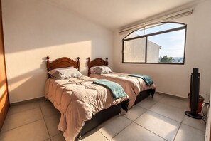 A bedroom with two beds, a large window, and a television. - Family Home | Excellent Location | 5B 3BR 2.5BA (Durango)