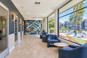 A modern lounge area with seating and a view of a pool and buildings. - Boulevard Stays Tempe 3BR 2BA near ASU, Pool, Gym (Tempe)
