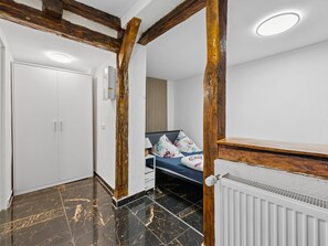 Ein Schlafzimmer mit einem Bett, einem Heizkörper, einem Kleiderschrank und einer Tür.