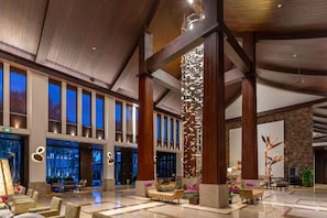 Eine geräumige Lobby mit hohen Decken, großen Fenstern und moderner Einrichtung.
