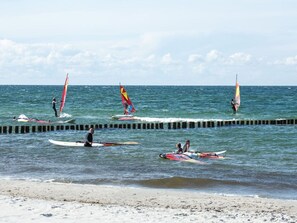 Ein Strand mit verschiedenen Windsurfaktivitäten.