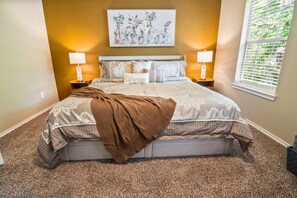 A bedroom with a large bed, two bedside lamps, a wall-mounted painting, and a window with blinds. - House 3-Bed 2,5-Bath FREE Parking - Nice Backyard (Spring)