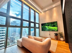 A modern living room with a large window, a flat-screen TV, and a sofa. -  5 Mins to Coex - Gangnam - Two Bedroom Apartment  -  Samsung Station (Seoul)
