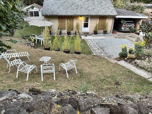 A residential property with a front yard, outdoor seating, and a garage.