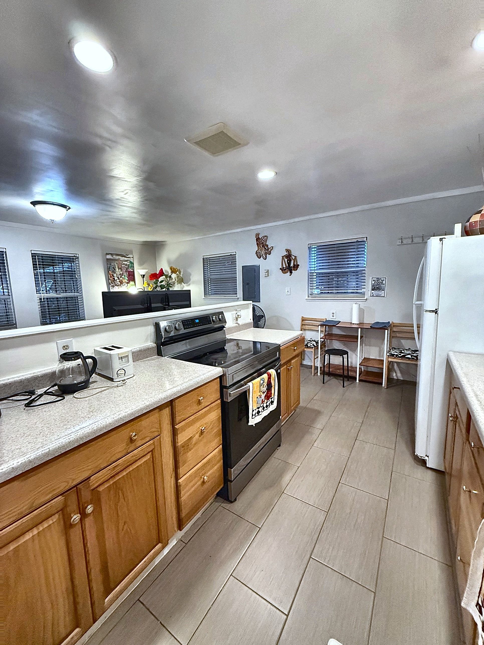 A kitchen with a stove, oven, and a dining area with a table and chairs.