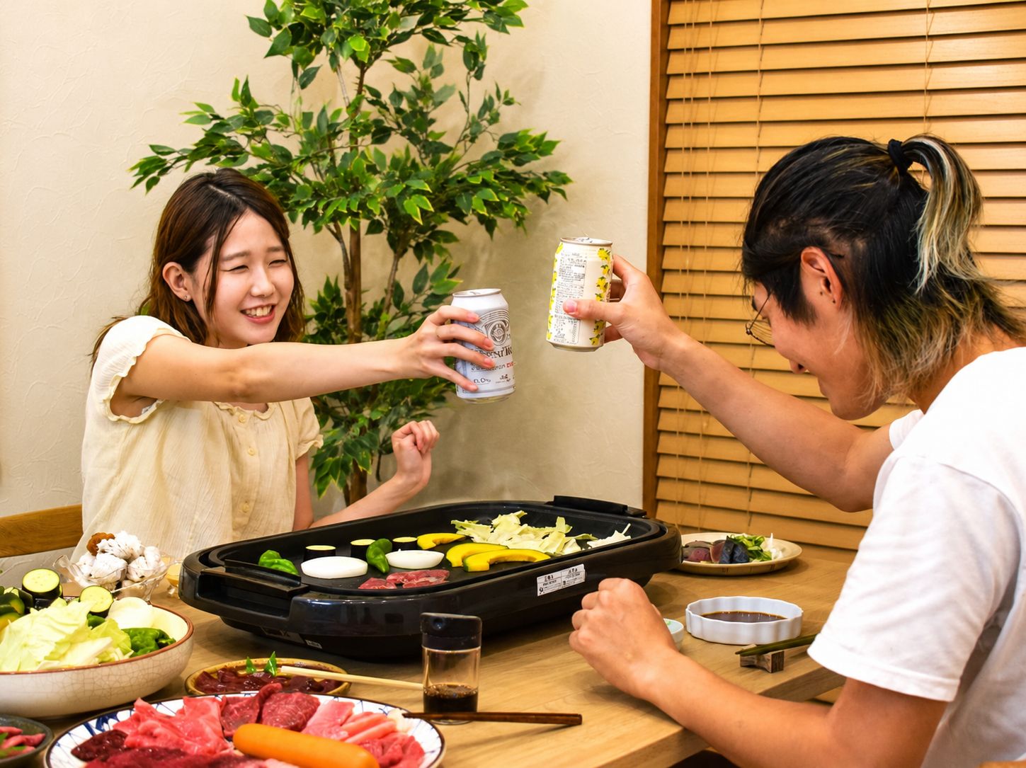 A dining table with a variety of food items, including vegetables, meat, and a hot plate.