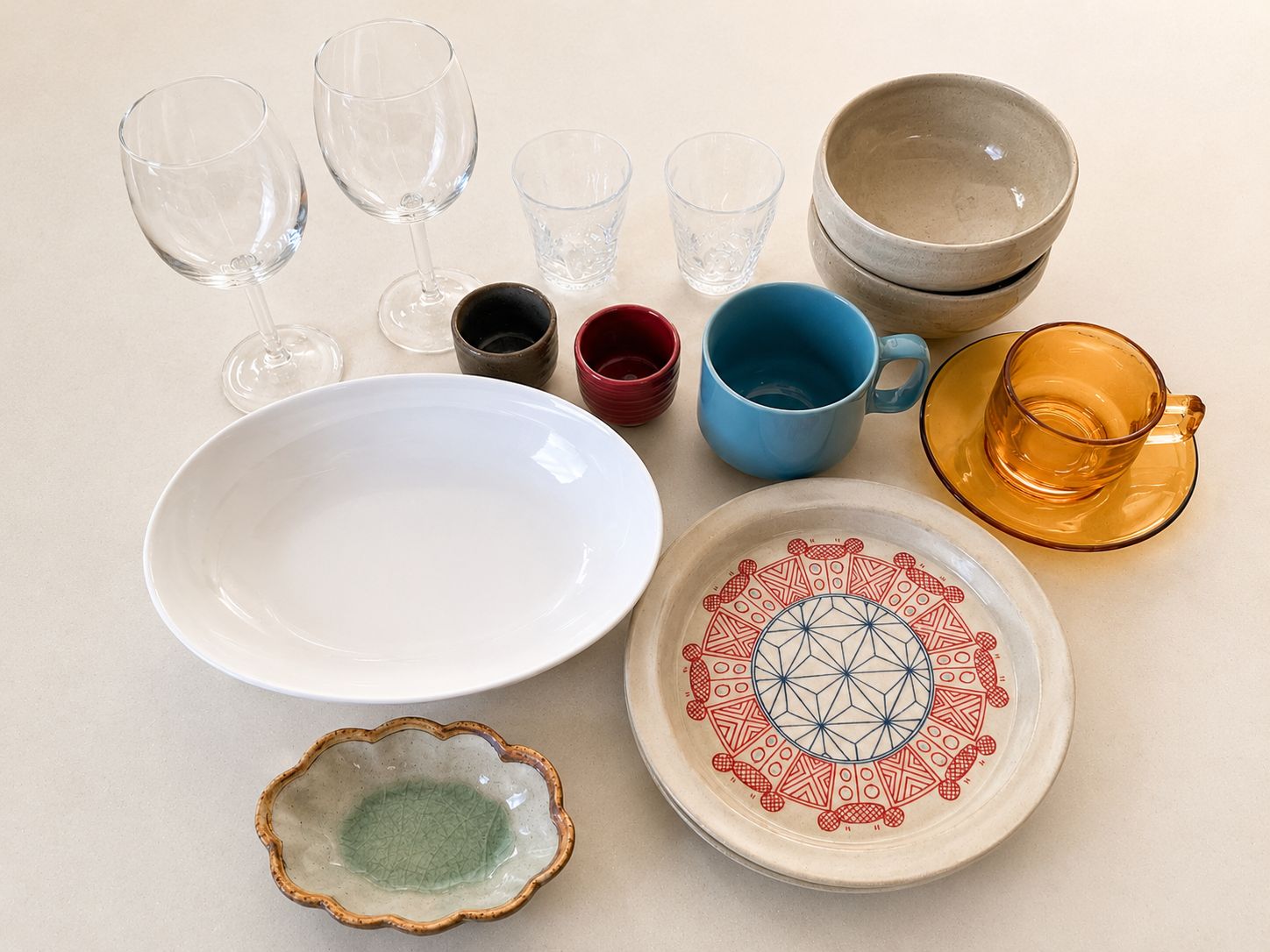 Een verzameling divers glazen servies en keramieken schalen.
