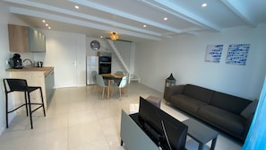 A modern living space with a kitchen, dining area, and a sofa. - New Listing (Saint-Vivien)