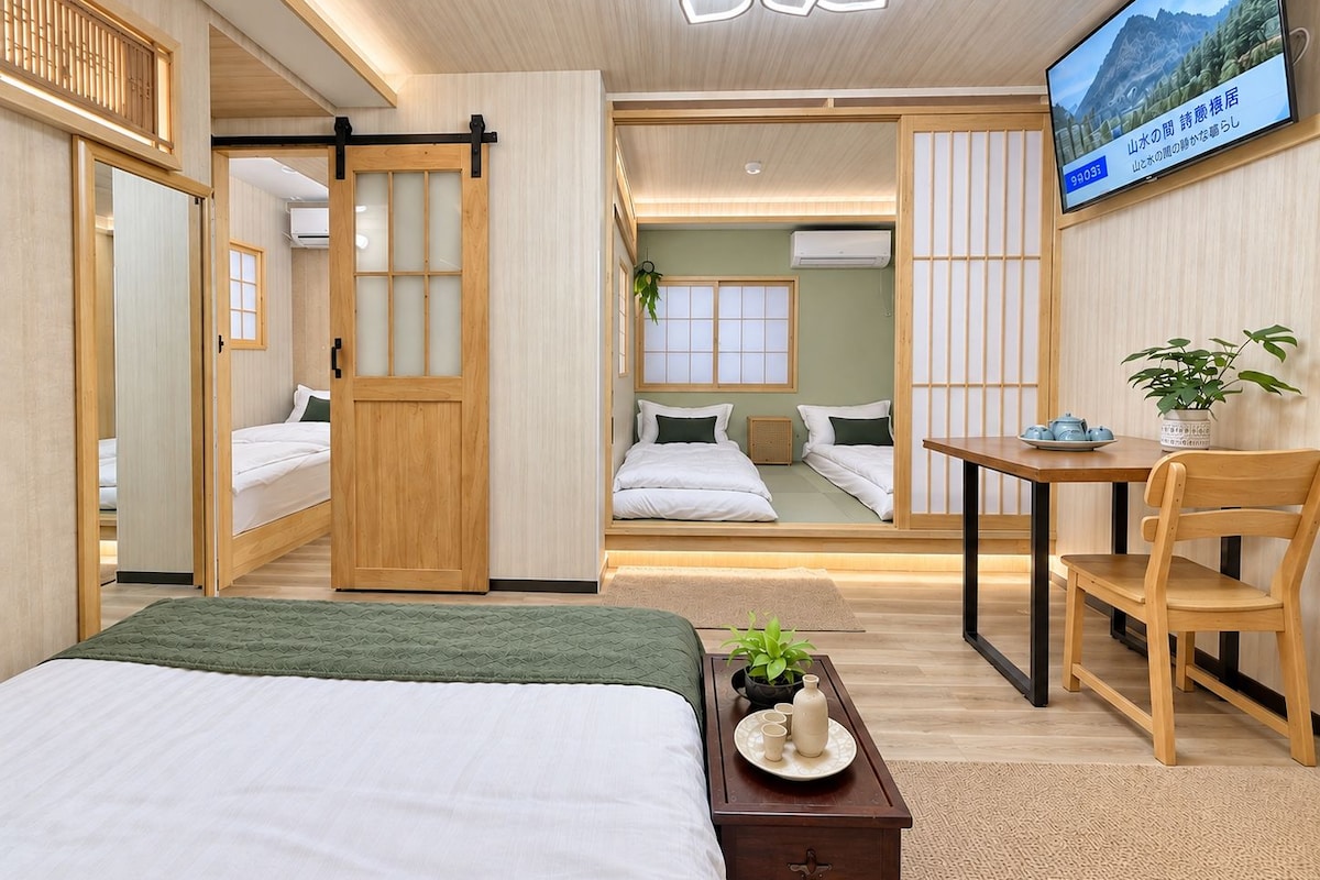 A modern hotel room with a bed, a desk, and a television.