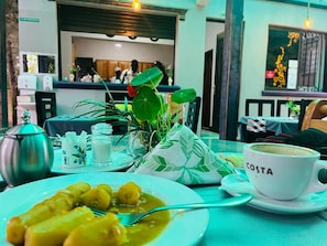 A dining table with a plate of food, a cup labeled 'COSTA,' and a teapot. - Nkokonjeru White Cove Mbarara (Mbarara)