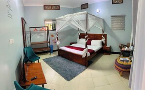 A bedroom with a four-poster bed, a small round table, a desk with a chair, and a mirror. - Nkokonjeru White Cove Mbarara (Mbarara)