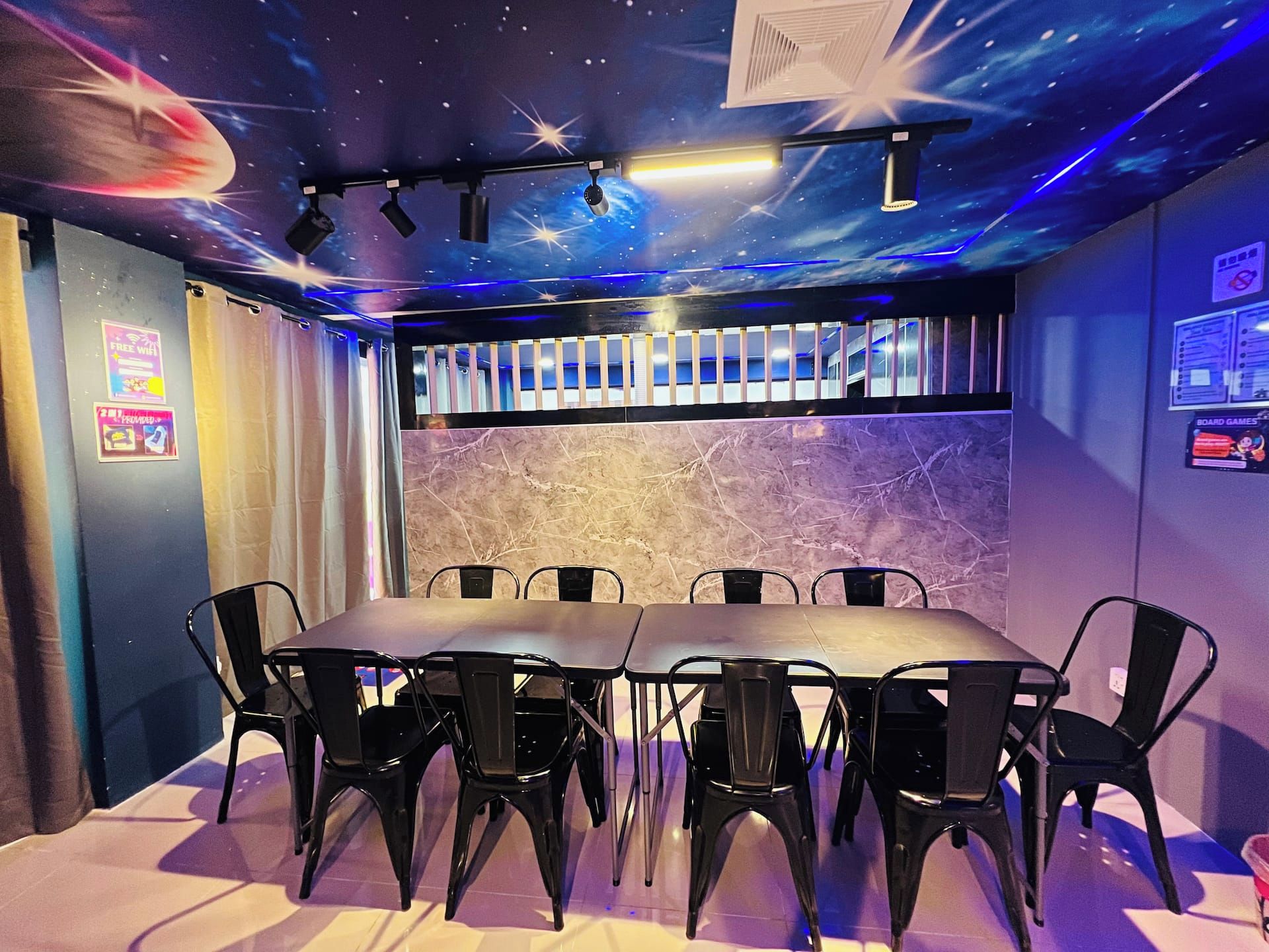 A room with a table and chairs, a ceiling with a starry design, and a wall with a marble texture.