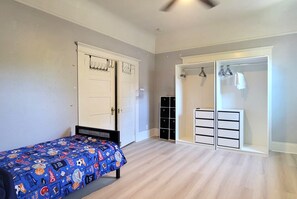 Ein Schlafzimmer mit einem Bett, einem Schrank, einem Kleiderschrank und einem Schuhregal.