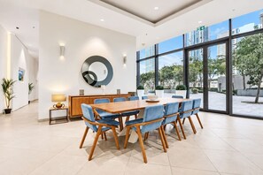 Een moderne vergaderruimte met een grote tafel, blauwe stoelen en een centraal hanglamp.