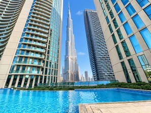 A swimming pool with modern high-rise buildings in the background. - FIRST CLASS | 1BR | Walk to Burj & Dubai Mall (Downtown)