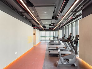 A gym with treadmills aligned along a corridor with large windows. - FIRST CLASS | 3BR | Elevated Luxury Near Downtown (Sobha Hartland)