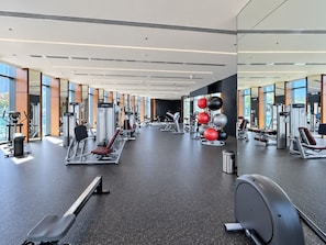 A modern gym with various exercise equipment, large windows, and a spacious layout. - FIRST CLASS | 1BR | Elegant w/ Dubai Mall Access (Dubai)