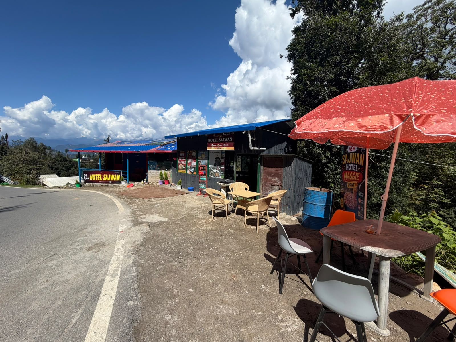 A roadside hotel with outdoor seating and a blue awning.