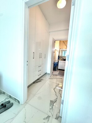 A hallway with a white wardrobe, a marble floor, and a pair of slippers on the floor. - Modern Luxury Home with Pool in Kiti - 4 bed 3 bath 2 kitchen (Kiti)