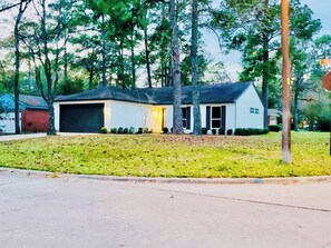 A single-story house with a garage, surrounded by a well-maintained lawn and trees. - House 3-Bed 2-Bath FREE Parking (The Woodlands)
