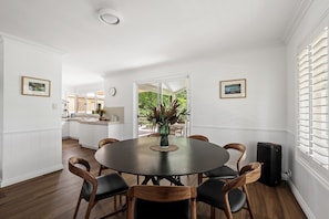 A dining area with a round table, six chairs, and a vase of flowers. - Windmill Farm | Space, Serenity | Rural Views (Forest Grove)