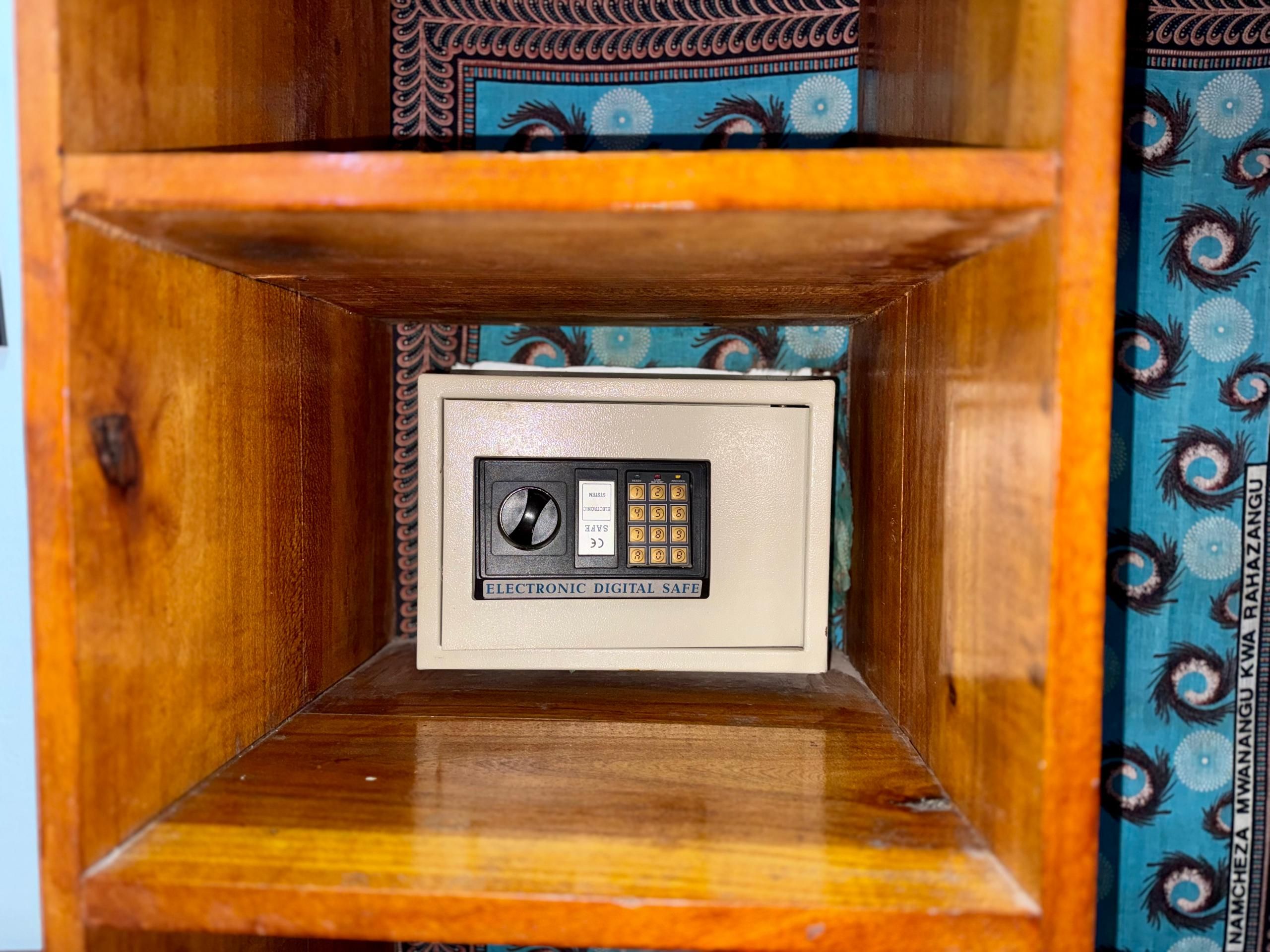 Un gabinete de madera con una caja fuerte digital en la repisa inferior.
