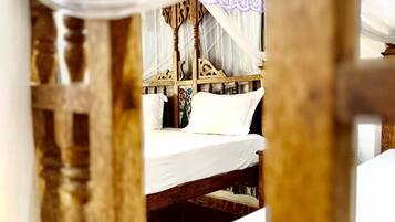 Una cama con dosel y cabecera de madera.