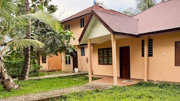 A two-story building with a covered porch and a well-maintained lawn.