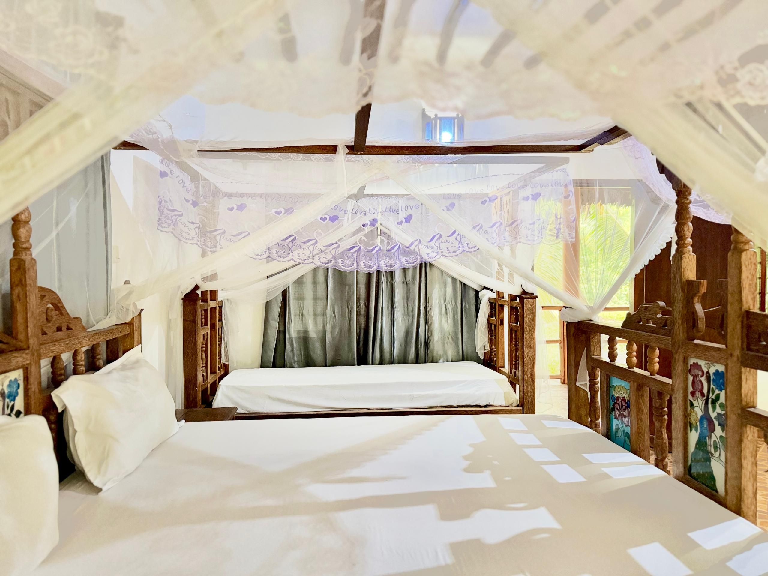 Un lit à baldaquin, avec une tête de lit en bois et des rideaux.