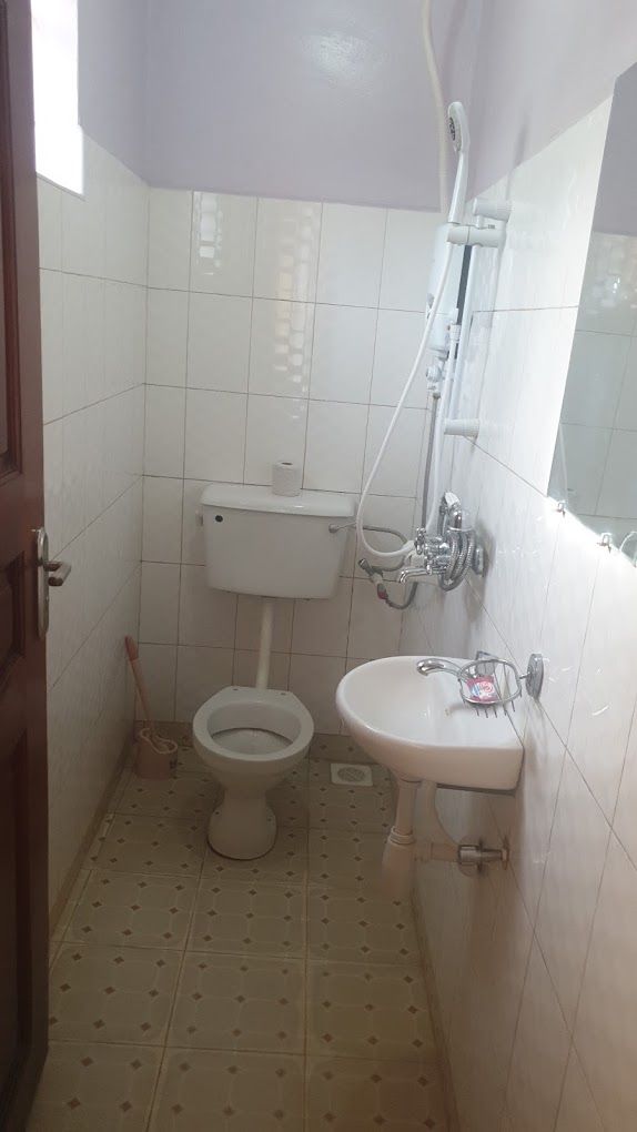 Un baño pequeño con inodoro, lavamanos y ducha.