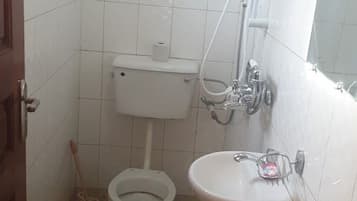 Un baño pequeño con inodoro, lavamanos y ducha.