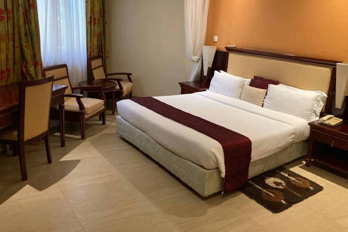 Ein Hotelzimmer mit einem großen Bett, einem Schreibtisch und einem Stuhl.