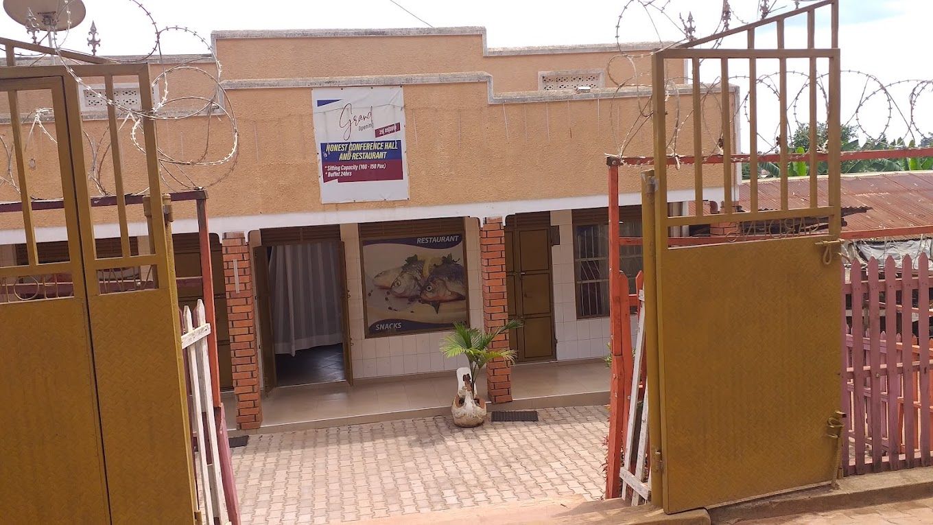 A gated entrance to a building with a sign advertising a conference hall and restaurant.