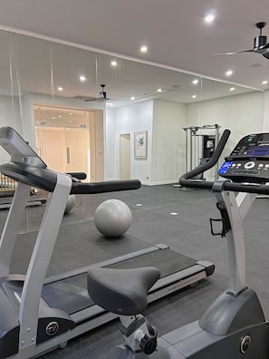 A gym with treadmills, a stationary bike, and a rowing machine. - MoonShadow Villa Phuket (Kathu District)