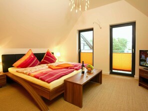 Ein Schlafzimmer mit einem Bett, Nachttischen, einem Fernseher und einem Fenster mit Blick.