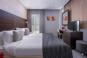 A hotel room with a bed, a desk, a television, and artwork on the wall. - Habitat Hotel Kilkis (Kilkis)