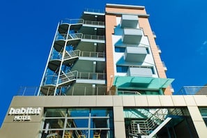 A multi-story hotel with a modern design, featuring balconies and a clear sky. - Habitat Hotel Kilkis (Kilkis)