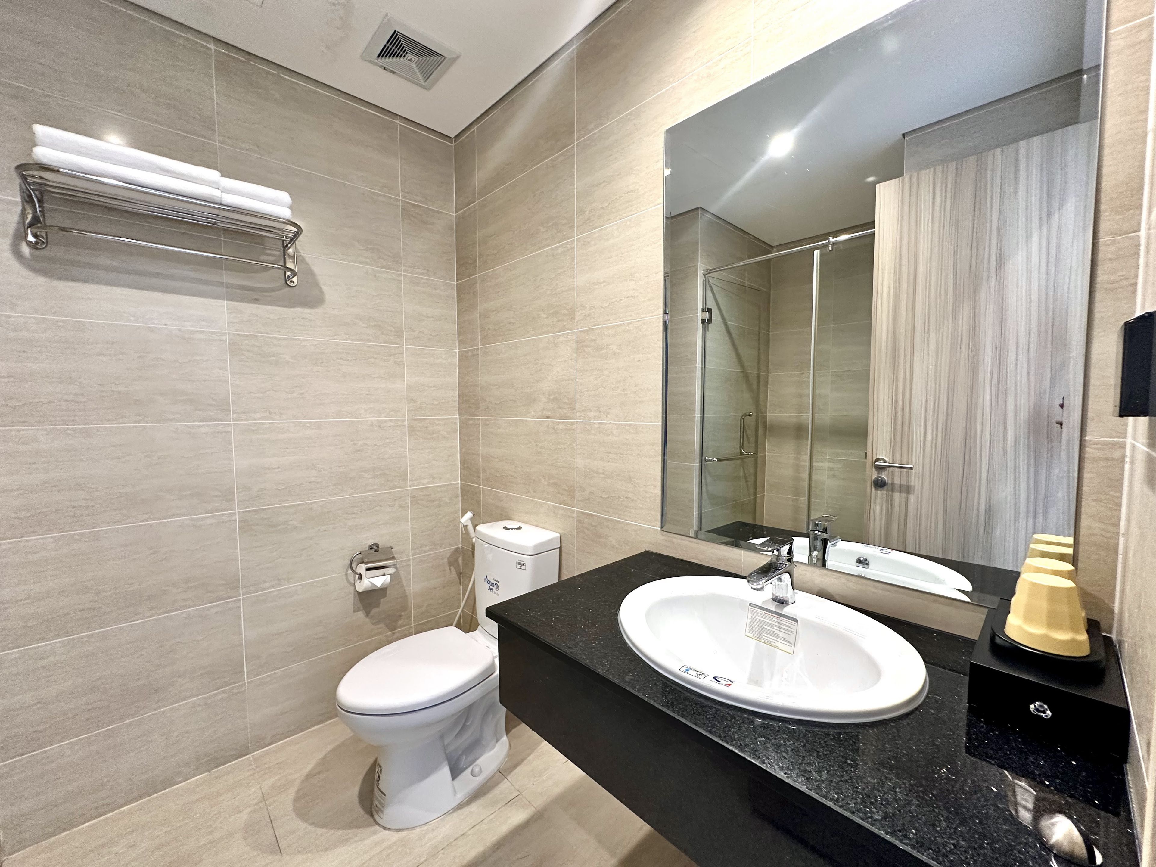 A modern bathroom with a toilet, sink, and shower.