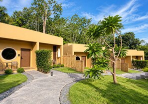A modern building with a circular window, a door, and a small patio area with a chair and table. - The AJ Sennava Krabi (Krabi)
