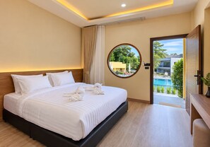 A hotel room with a bed, a round window, and a view of a swimming pool. - The AJ Sennava Krabi (Krabi)