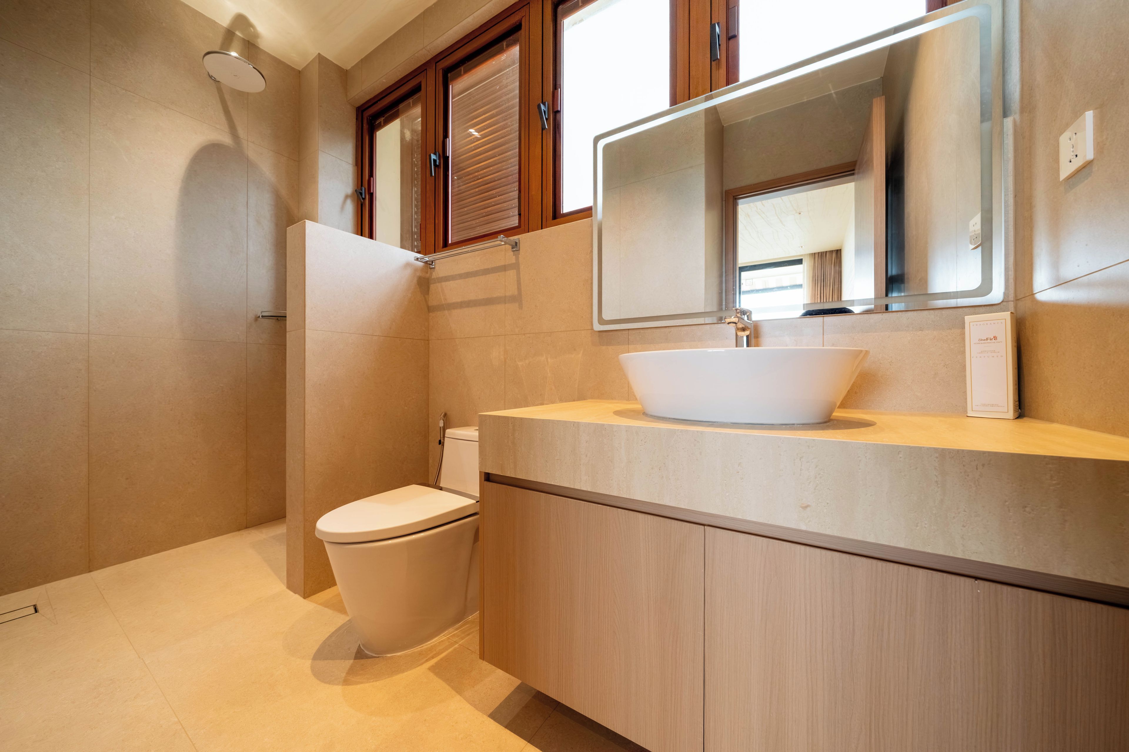 Ein modernes Badezimmer mit Toilette, einem Waschbecken mit Vessel-Becken und einem Spiegel darüber.