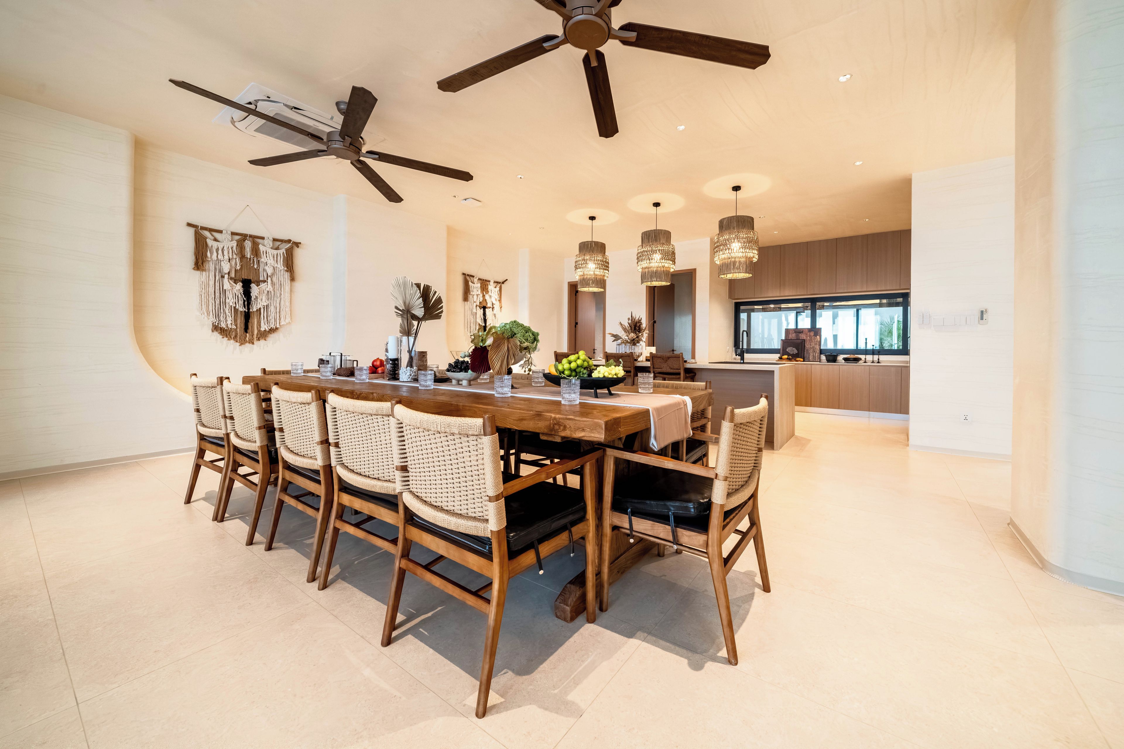 A spacious dining area with a wooden table and chairs, a ceiling fan, and a view into the kitchen.