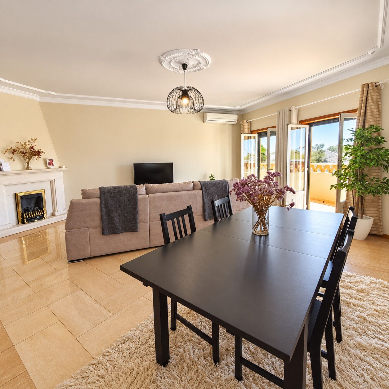A modern living room with a sofa, a dining table, and a TV.
