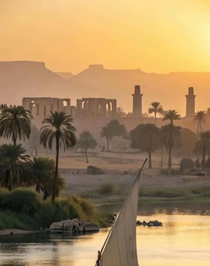 A sunset view with palm trees and ancient ruins in the background. - Vesta - Luxury APT - 2BR - Bay Central (Soma Bay)