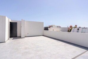A rooftop terrace with a closed door, a flat roof, and a clear sky. - Yamas Urban Living Olympia Suites Old Town Studio (Lemesos)