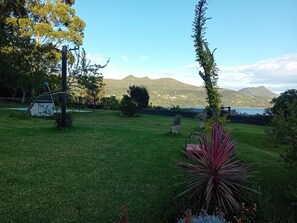 A grassy outdoor area with a view of mountains and a body of water. - New Listing (Busturia)