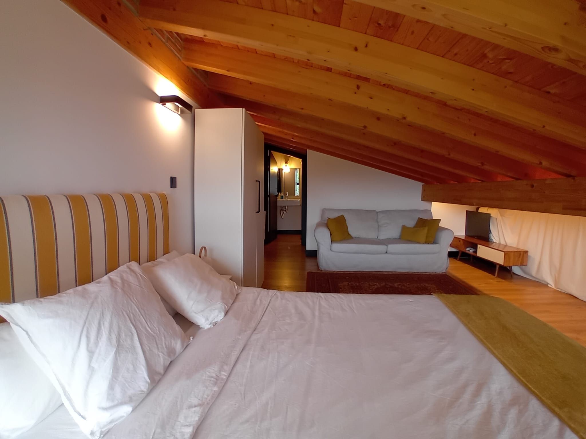 Ein Schlafzimmer mit einem Bett, einem Sofa und einem Schreibtisch.